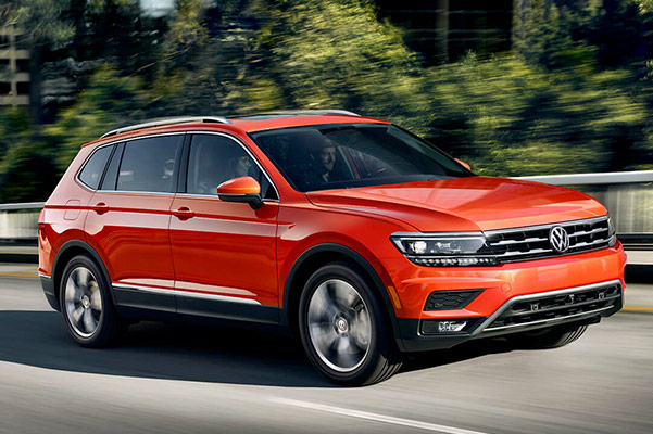 side view of the 2019 VW Tiguan in orange driving down the road