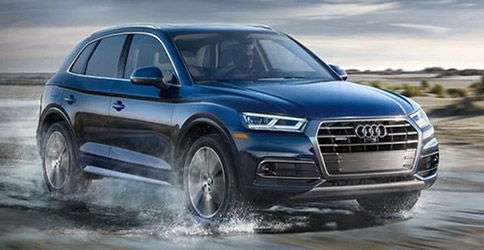 blue Audi Q5 at high speed with water in the ground showcasing all wheel drive features