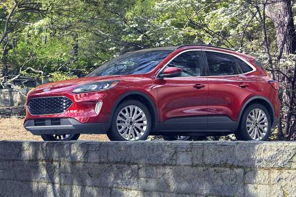 side view of red Ford Escape crossover parked in front of a park