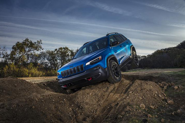 blue jeep cherokee driving through holes and tough terrain