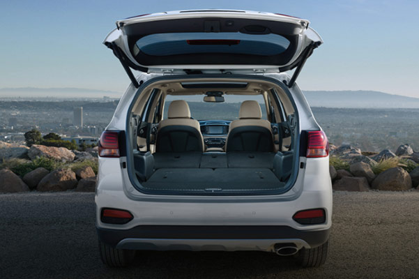 rear view of kia sorento suv with the back door open with mountains in the background