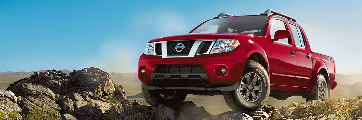 2020 Nissan Frontier midsize pickup truck in Cayenne Red Metallic on a rocky plain