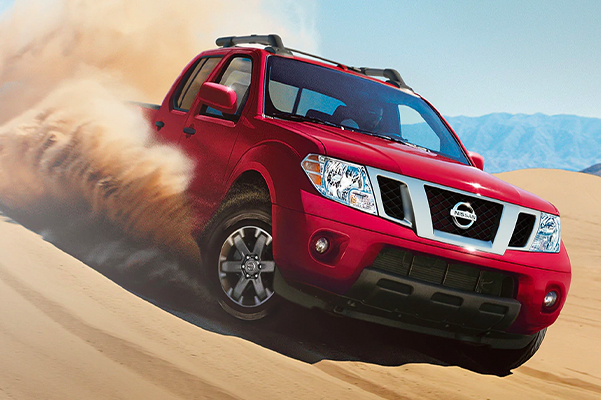 2020 Nissan Frontier in Cayenne Red Metallic driving down a dune face