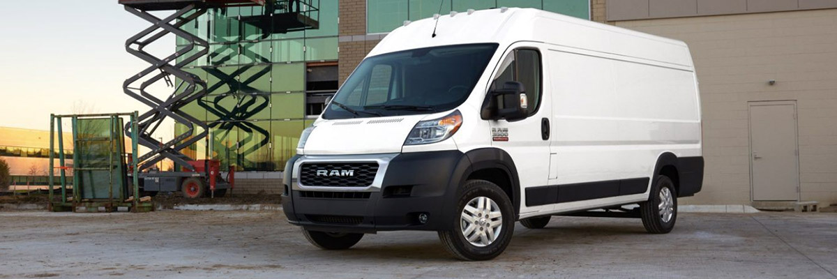 A three-quarter front view of a 2020 Ram ProMaster parked next to a commercial building.
