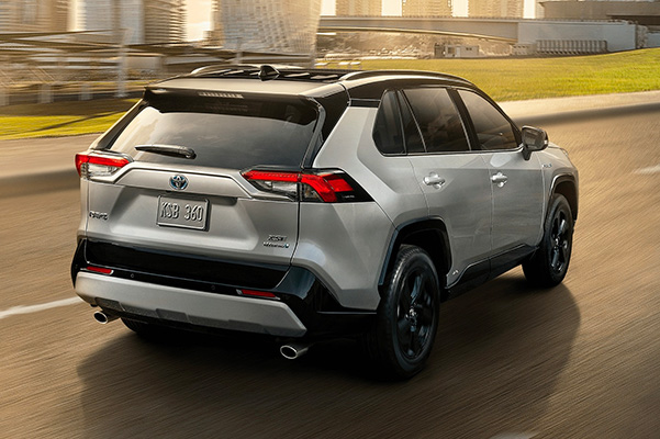 Exterior rear view of a 2020 Toyota RAV4 driving down a road