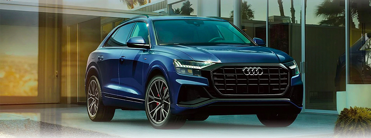 Three-quarter front profile of the Audi Q8 parked in driveway.