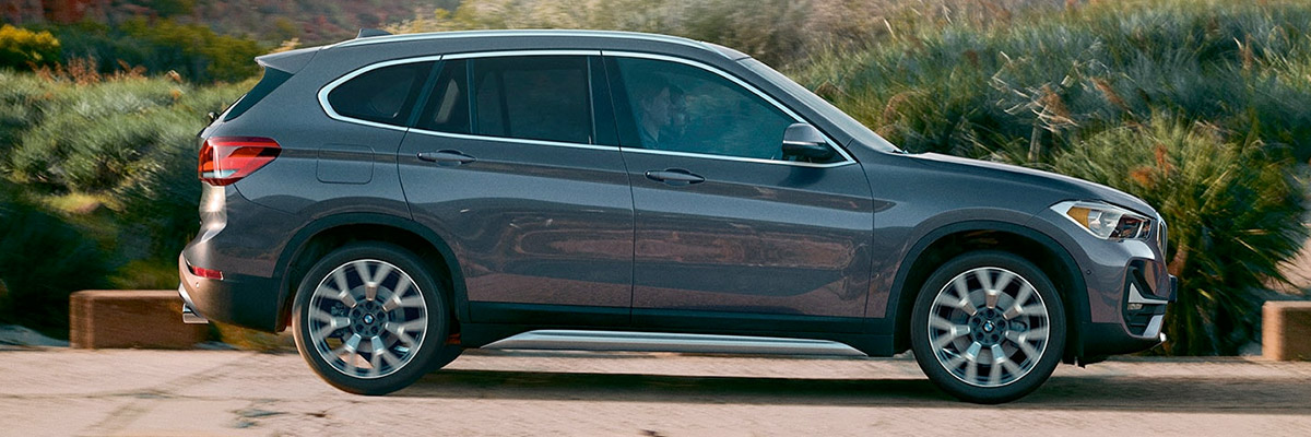 side profile of the 2022 BMW X1 driving through a natural setting