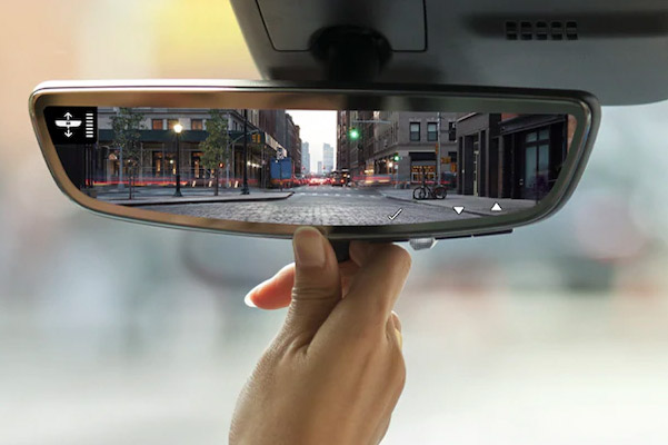 close up of a hand touching the 2021 Cadillac XT4 rearview mirror featuring back up camera