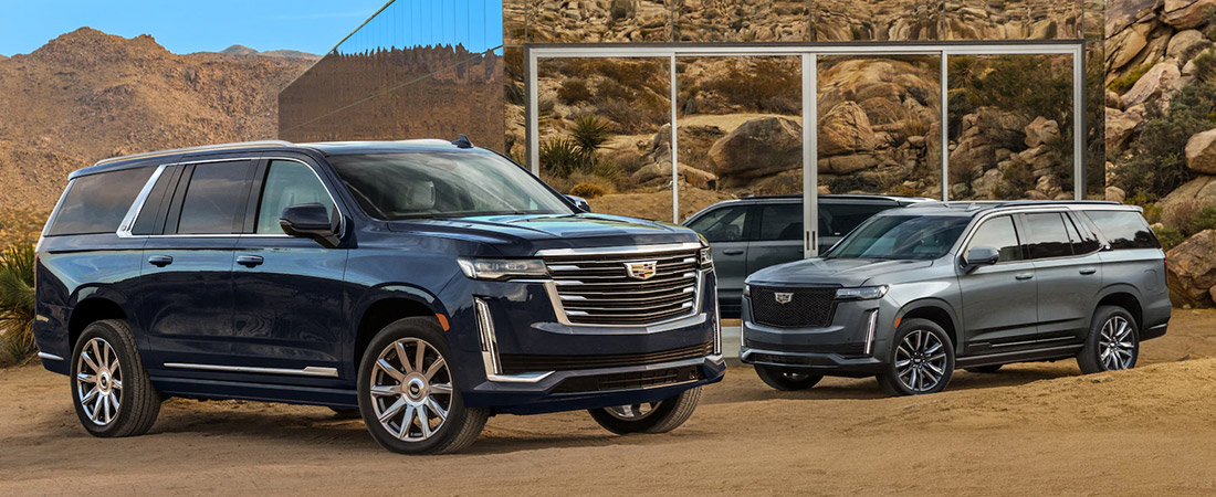two 2021 cadillac escalade parked side by side on a desert setting
