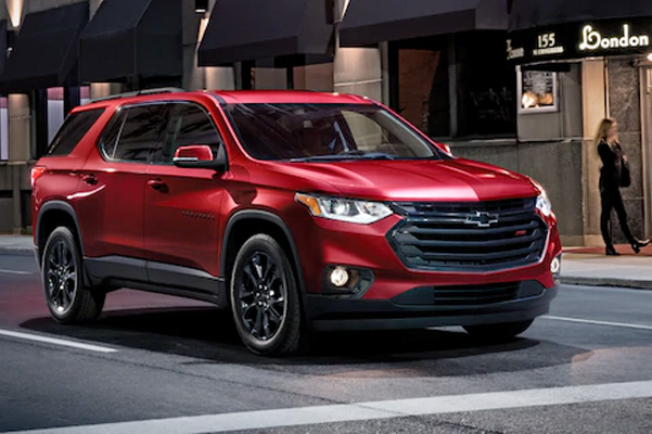 2021 Chevrolet Traverse driving down city road at night