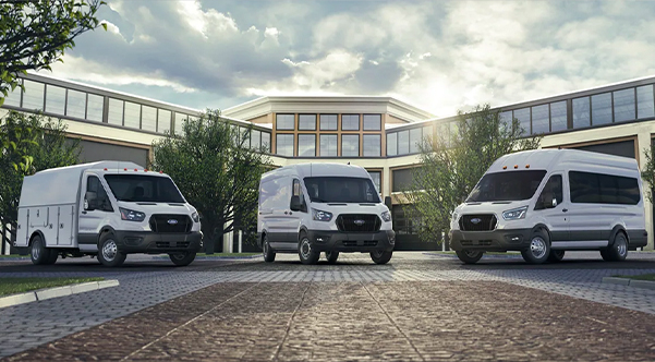 2021 Ford® Transit lineup parked in front of a large building
