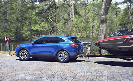 blue 2021 Ford Escape towing a boat