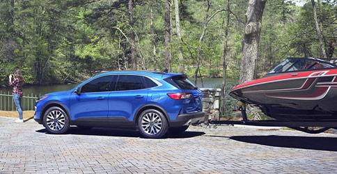 blue 2021 Ford Escape towing a boat