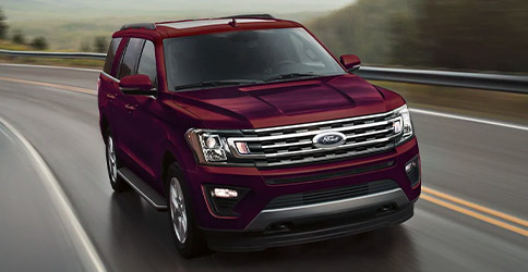 2021 Ford Expedition in Burgundy Velvet Metallic Tinted Clearcoat with 10 speed Select Shift automatic transmission on a mountain road