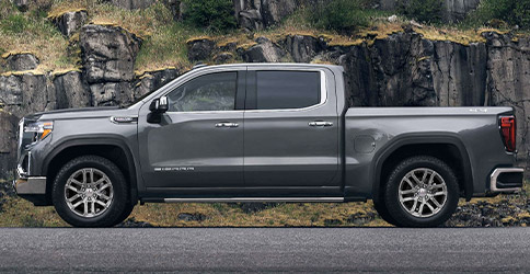 Side profile of a 2021 GMC Sierra 1500 parked in front of a mountain