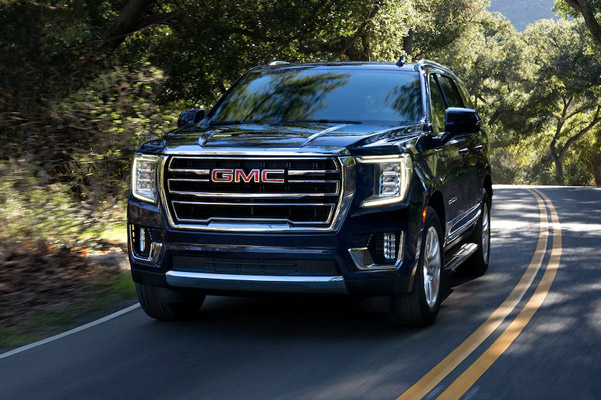 2021 GMC Yukon driving down wooded road