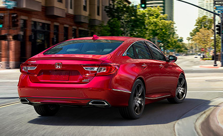 red 2021 honda accord showcasing adaptive damper system while taking a turn on a street curve
