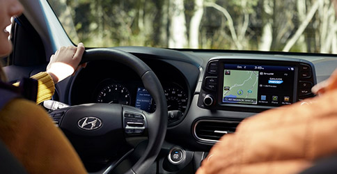 close up of a person driving the hyundai kona suv featuring driver dashboard and digital screen