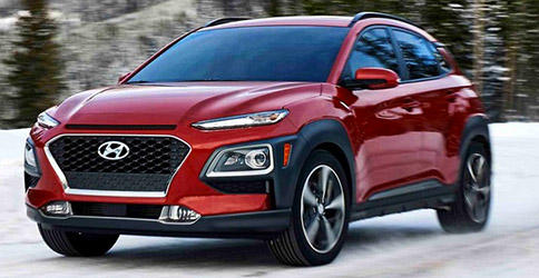 frontal side profile of hyunai kona suv in red color driving on a road with snow