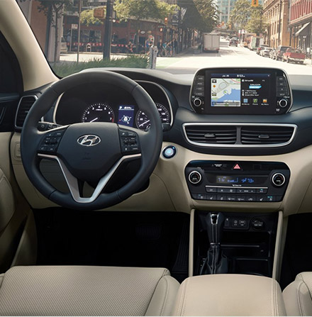 interior view of Hyundai Tucson suv featuring dashboard, lether seats and digital navigation