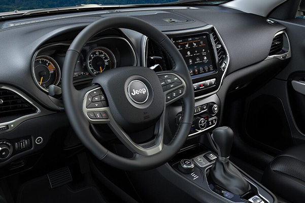 A close-up of the steering wheel and dashboard in the 2021 Jeep Cherokee.