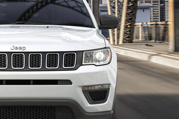 A head-on view of the 2021 Jeep Compass being driven over a bridge.