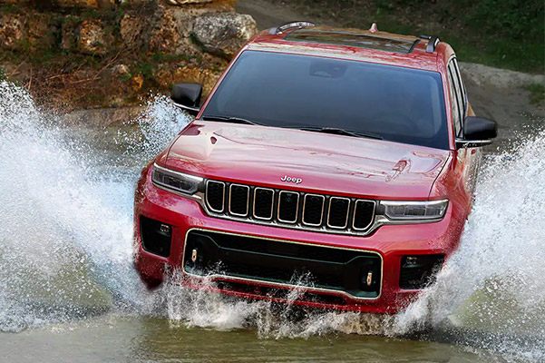 The 2021 Jeep Grand Cherokee Limited being driven around a bend in the road.