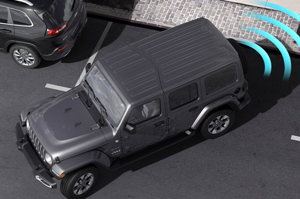 Illustration of sensors monitoring the area behind the 2021 Jeep Wrangler Sahara as it parallel parks at a curb.