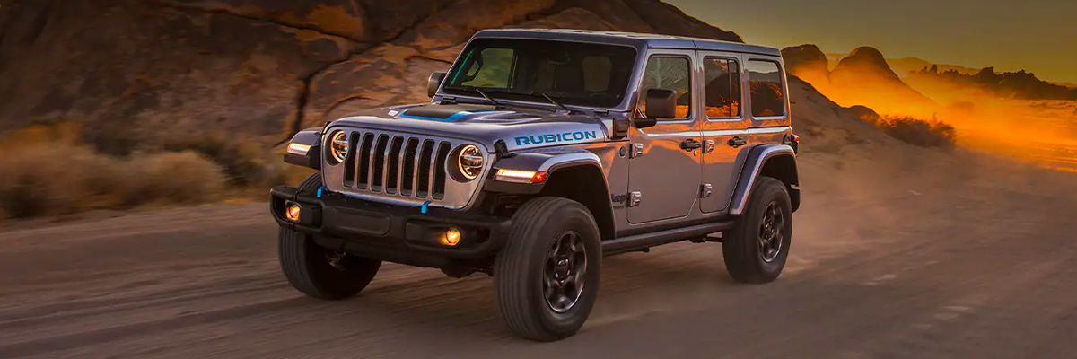The 2021 Jeep Wrangler 4xe being driven off-road on sandy terrain.