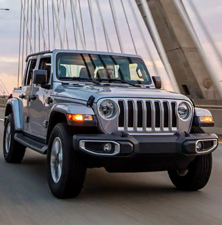 The 2021 Jeep Wrangler Sahara being driven over a suspension bridge.
