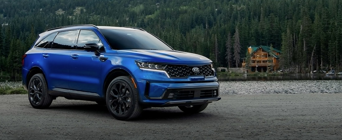 2021 Kia Sorento Parked In Front Of A Cabin And Trees Three-Quarter View