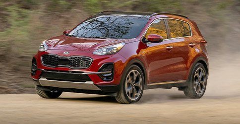 red 2021 kia sportage driving on the dirt