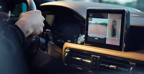 The center stack shows a split screen view of the three sixty degree camera display feature with a birds eye view of the vehicle and surroundings
