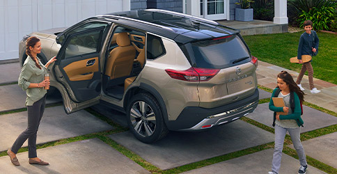 2021 Nissan Rogue in a driveway with door open for family to get in