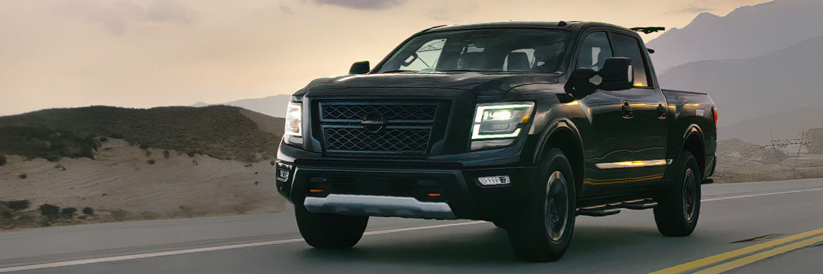 2021 Nissan TITAN Crew Cab in black on a highway at sunset