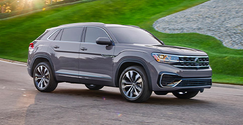 2021 VW Atlas Cross Sport shown driving down a road on a sunny day