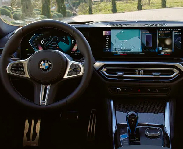A driver's eye view of steering wheel and controls of the BMW i4