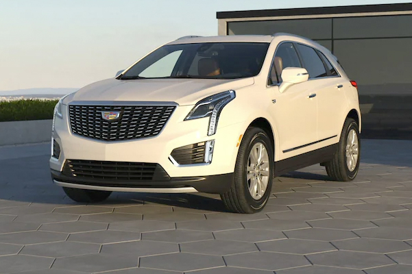 white 2022 Cadillac XT5 parked in front of a building during sunset