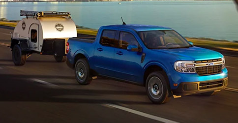 2022 Ford Maverick LARIAT with available 4K Tow Package hauls a trailer away from the city