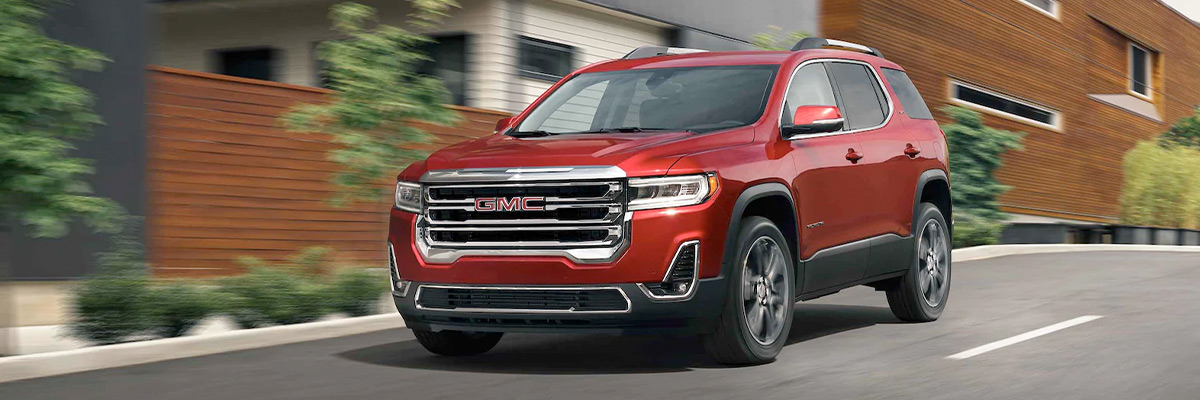 Red 2022 GMC Acadia driving on a road