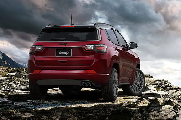 A rear view of the 2022 Jeep Compass parked atop a rocky outcropping.