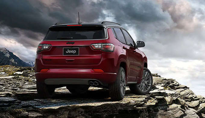 A rear view of the 2022 Jeep Compass parked atop a rocky outcropping.