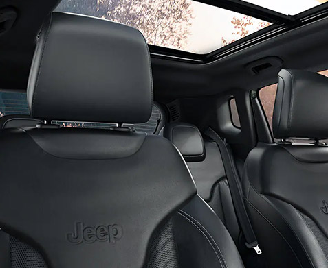 The open sunroof and front seats in the 2022 Jeep Compass.