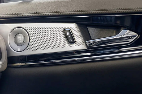 A speaker cover and door controls are shown in a 2022 Lincoln Nautilus to highlight craftsmanship details and flowing chrome