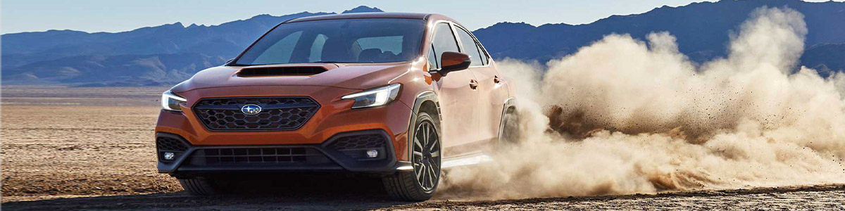 The 2022 Subaru kicking up dirt while driving on a desert road.