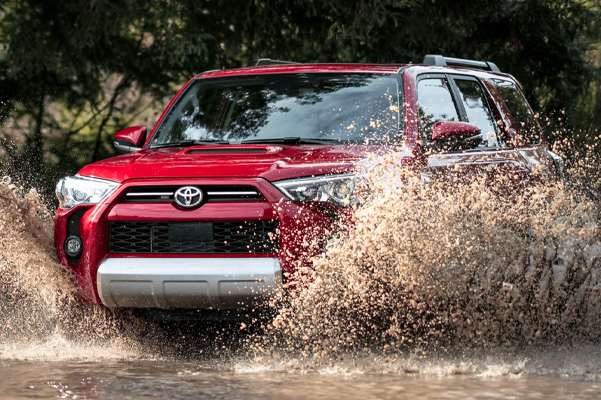 TRD Off-Road Premium shown in Barcelona Red Metallic. Prototype shown with options driving through muddy water.