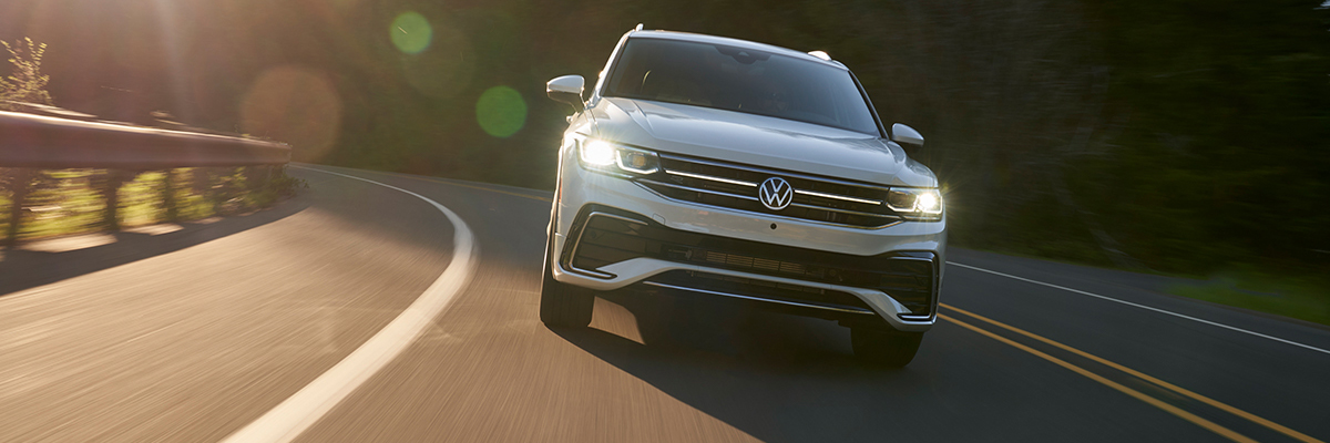 2022 vw tiguan driving down the road during sunset