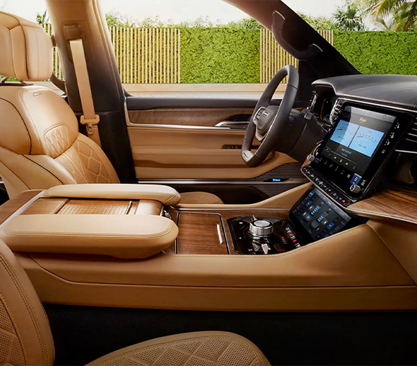 The driver and front passenger seats in the 2023 Grand Wagoneer Series III accented in American walnut on the console and dashboard.