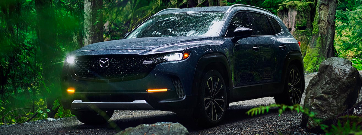 2023 Mazda CX-50 driving through a forest