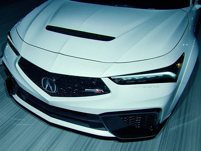 Acura Integra Type S in motion, front close up showing grille with Type S badge and headlight